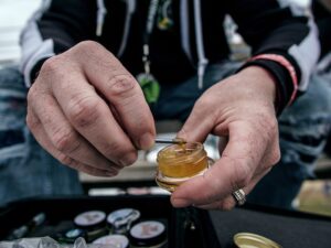 a man holding a container of cannabis extract